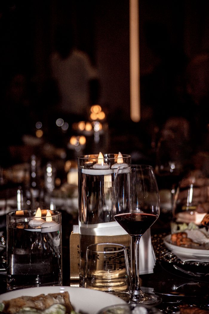 about-img-01 A beautifully set dinner table with candles and wine, creating a warm and inviting atmosphere.