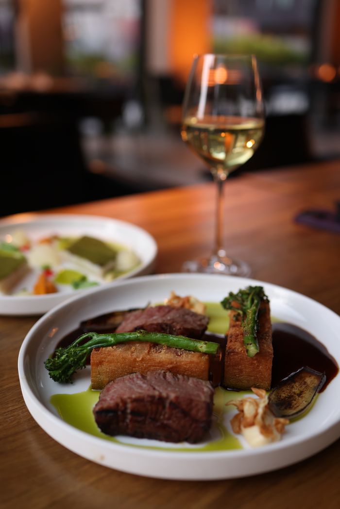 gallery-02 Savoring a gourmet steak dinner with wine in a cozy restaurant setting.