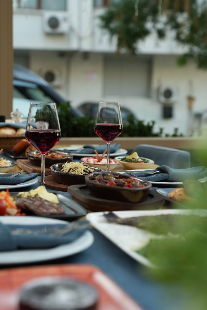 services-04 Sophisticated dining setup outdoors showcasing red wine and gourmet dishes in an elegant atmosphere.