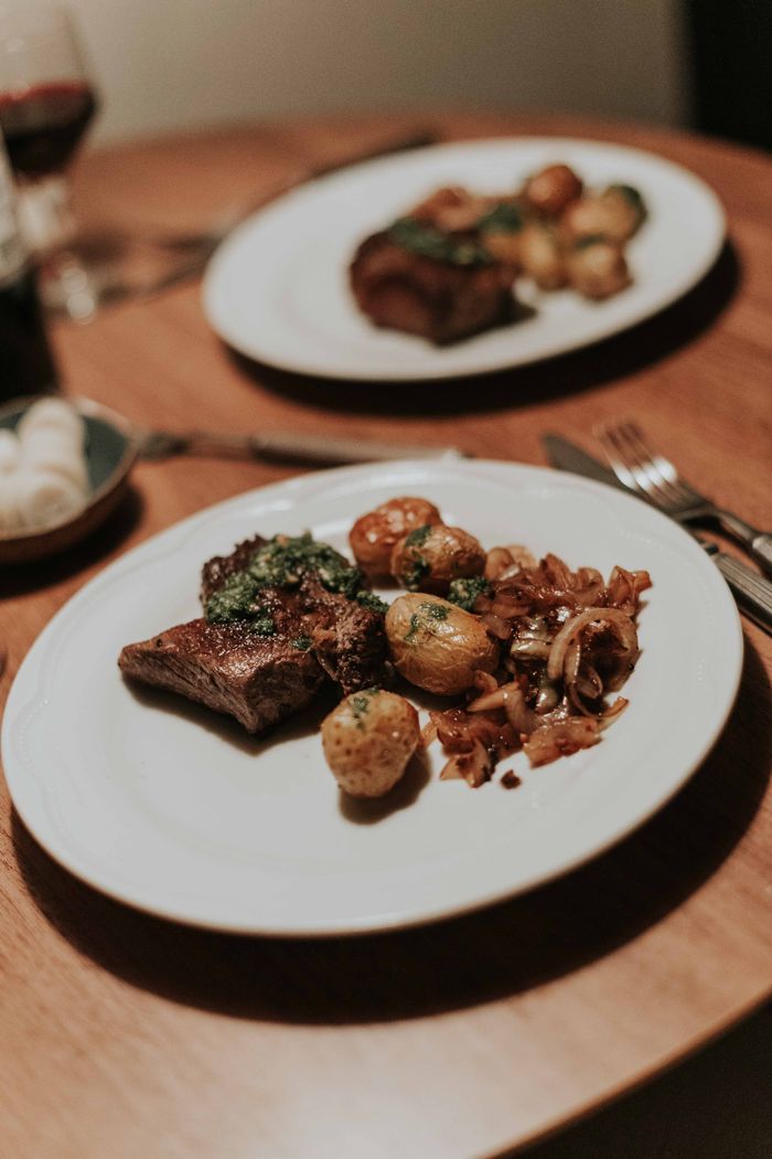 journey-01 Tantalizing steak and herb potatoes on a beautifully set dinner table.