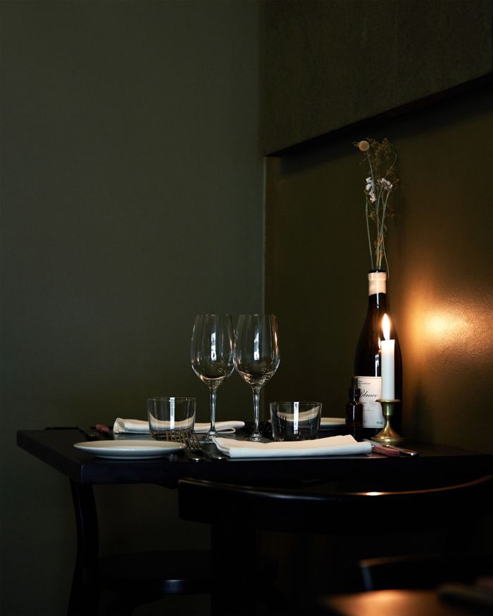 gallery-05 Elegant restaurant table with wine glasses, candle, and bottle, evoking a romantic evening ambiance.